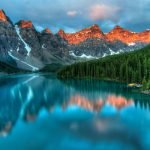 Capture the serene beauty of Moraine Lake with sunrise reflections in Banff National Park.